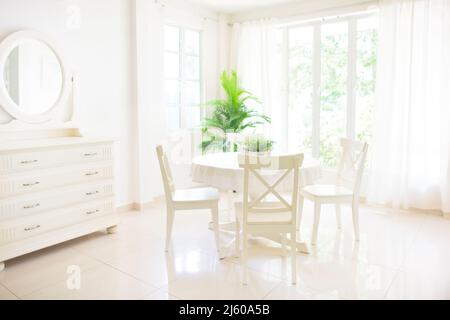 Home interior. Dining room design. Table and chairs in white sunny house. Kitchen breakfast area in family apartment. Stock Photo