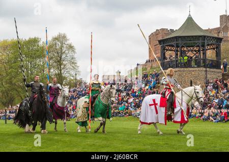 Knights wearing armour hold jousting poles whilst riding horses at a medieval re-enactment. Stock Photo