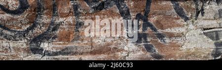 Panorama view of old rust colored concrete wall with black and white paint markings Stock Photo