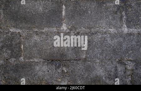 Old dark gray concrete block wall with gray mortar Stock Photo
