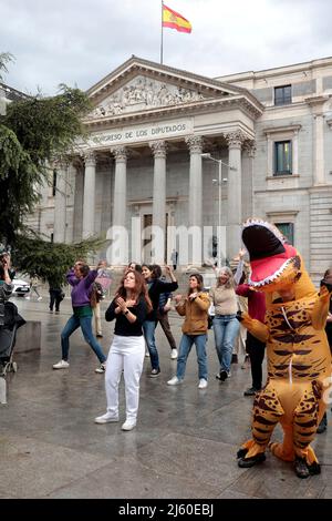 Madrid, Spanien. 26th Apr, 2022. Madrid Spain; 26.04.2022.- A group of people belonging to Ecologists in Action demonstrate in front of the Spanish parliament with a performance of an inflatable dinosaur TCE-REX that represents the Energy Charter Treaty to which Spain and 52 other countries belonged. Europe and Asia and incompatible with the objectives of the Paris Agreement. They accompanied him with a choreography together with three people dressed as dinosaurs. Credit: Juan Carlos Rojas/dpa/Alamy Live News Stock Photo