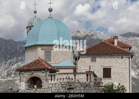 Close up of the two blue domes of  a catholic church in the middle of a inlet with terracotta tiles on the roof Stock Photo