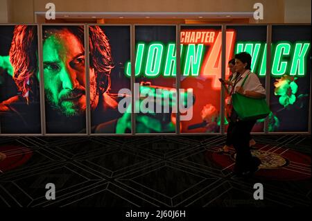 Attendees pass by movie posters at the CinemaCon trade show at