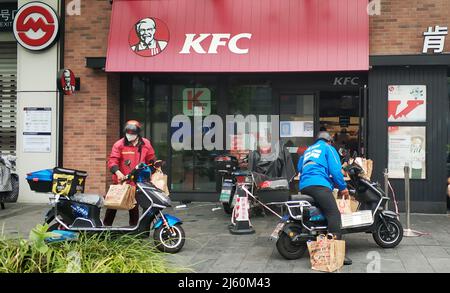 SHANGHAI, CHINA - APRIL 26, 2022 - Deliverymen work at the gate of KFC on April 26, 2022 in Shanghai, China Stock Photo