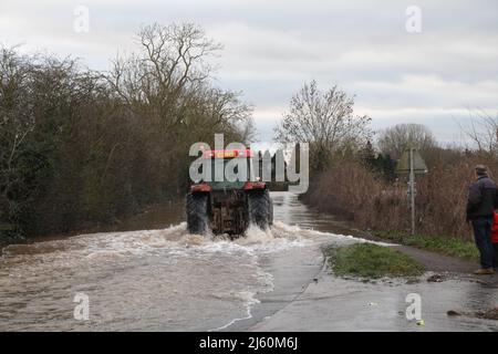 Ryall,  Worcestershire. 11th Feb, 2014. A tractor negotiates the flooded A4104 at Ryall near Upton upon Severn at Ryall Worcestershire England Stock Photo