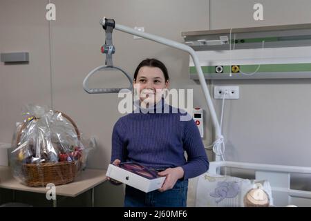 Kyiv, Ukraine. 26th Apr, 2022. Kira Obedinska holds her new iPad present by Ukrainian President Volodymyr Zelenskyy, at the Okhmatdyt National Childrens Specialized Hospital, April 26, 2022 in Kyiv, Ukraine. The girl is one of two orphans evacuated from Mariupol during the Russian attack on the city. Credit: Ukraine Presidency/Ukraine Presidency/Ģ����ý Live News Stock Photo