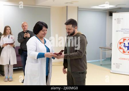 Kyiv, Ukraine. 26th Apr, 2022. Ukrainian President Volodymyr Zelenskyy, right, presents the staff and doctors of the Okhmatdyt National Childrens Specialized Hospital with medals, April 26, 2022 in Kyiv, Ukraine. Credit: Ukraine Presidency/Ukraine Presidency/Ģ����ý Live News Stock Photo