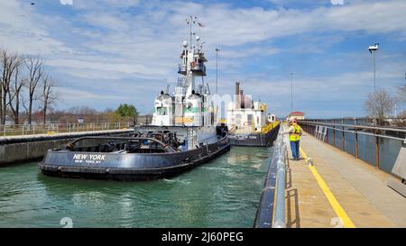 The barge Double Skin and tugboat New York transit the Black Rock Lock in Buffalo, New York, April 25, 2022. The barge was the first major vessel of the commercial shipping season to transit the lock, which provides the only means for deep draft commercial vessels on the Great Lakes to reach delivery ports on the upper Niagara River. (U.S. Army Photo by Avery Schneider) Stock Photo