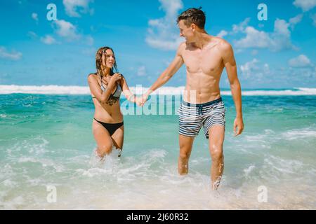 January 28, 2020. Bali, Indonesia. Couple swim in tropical ocean. Honeymoon in paradise island Stock Photo