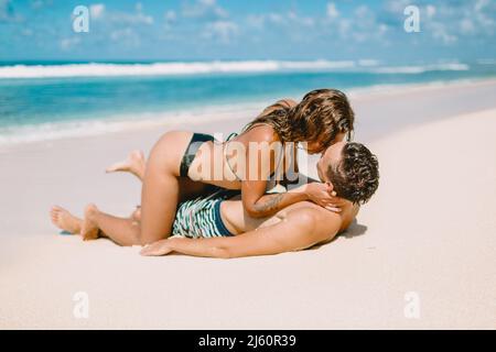 January 28, 2020. Bali, Indonesia. Young couple kiss at tropical ocean beach. Stock Photo