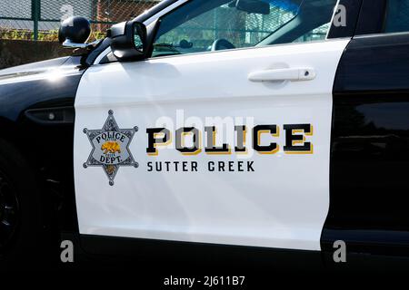 Police sign and Sutter Creek Police Department badge on the side of police vehicle - Sutter Creek, California, USA - 2022 Stock Photo