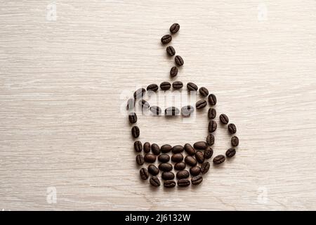 Coffee cup made from beans on white background. coffee bean close-up on a wooden table. coffee break, Stock Photo