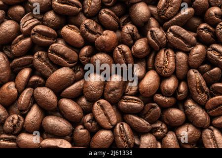 Coffee Beans Background. Close Up. A macro photo of roasted coffee beans on the table. Stock Photo