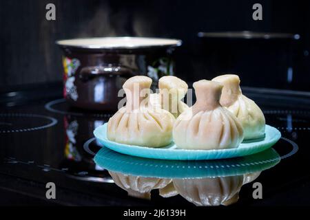Traditional georgian dampling known as khinkali in georgian on black plate on black background Stock Photo