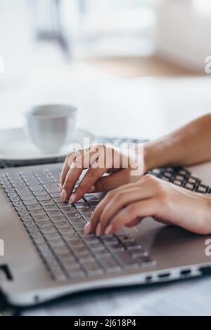 Woman using laptop typing on the keyboard Female hands close up. Stock Photo