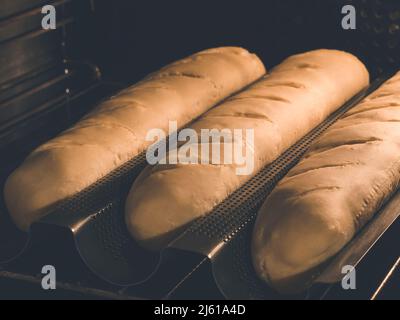 image shows hot to bake your own organic homemade crusty french bread - baguette in pan Stock Photo