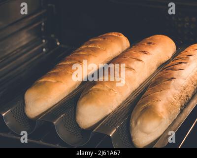 how to bake your own perfect homemade baguette or sandwich bread in special baguette or french bread pan Stock Photo