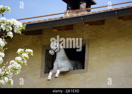 white plastic horse decoration out of the window on house in Ticino Stock Photo