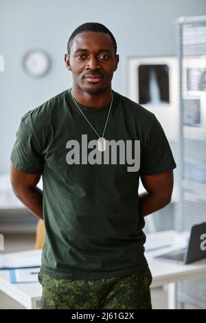 Portrait of handsome young African American military officer standing at doctors office looking at camera Stock Photo