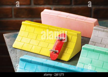 Multi-colored plaster ramps and fingerboard on the table, close-up Stock Photo