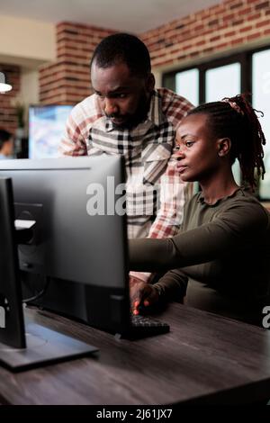 Creative agency production department workers trying to solve development issues of 3D project. Software company employees brainstorming design ideas while sitting in office workspace. Stock Photo