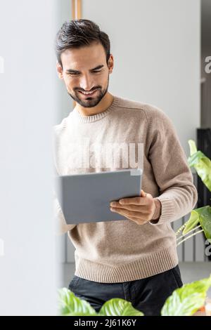 Smiling man using tablet PC at home Stock Photo