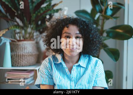 Smiling curly-haired woman at home Stock Photo