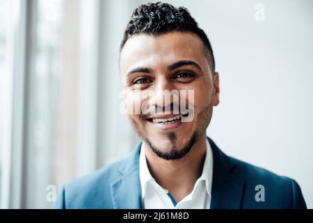 Happy businessman with black hair in office Stock Photo