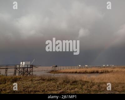 Stormy weather on Atlantic west coast near La Rochelle, Charente Maritime, France dramatic clouds over fishing huts along coastline Stock Photo