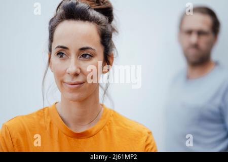 Thoughtful woman standing in front of man Stock Photo
