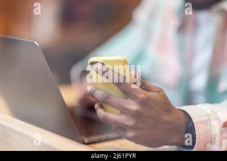 Man with laptop using smart phone at cafe Stock Photo