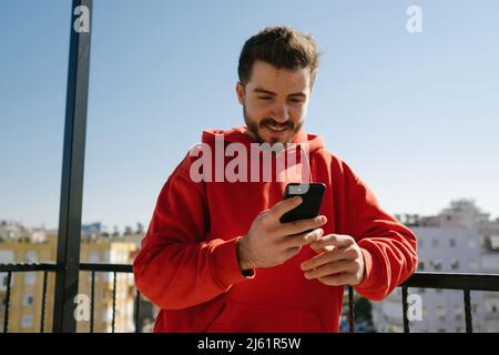Looking at the phone, handsome adult surfing internet, having fun on social media and watching funny videos Stock Photo