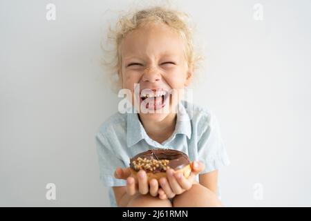 Cheerful girl holding doughnut and laughing Stock Photo