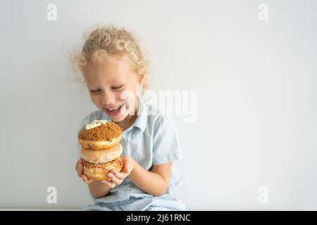 Happy girl holding stack of doughnuts Stock Photo