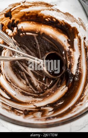 Scooping cupcake batter with a dough scoop into cupcake foil liners to bake  gingerbread cupcakes Stock Photo - Alamy