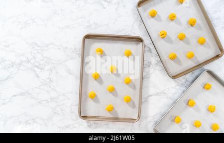 https://l450v.alamy.com/450v/2j61w05/lemon-cookies-with-white-chocolate-flat-lay-scooping-cookie-dough-with-dough-scoop-into-a-baking-sheet-lined-with-parchment-paper-to-bake-lemon-cook-2j61w05.jpg