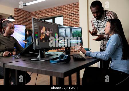 Footage editing specialist using multi monitor workstation to improve