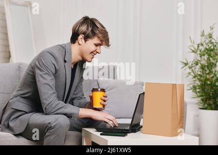 man sit on the couch and shopping in internet stores Stock Photo