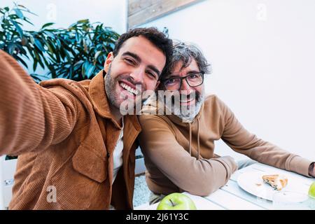 Happy father and son taking selfie and having breakfast together Stock Photo