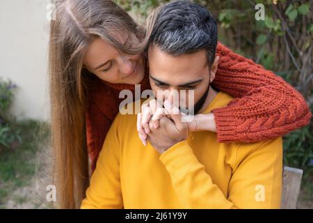 Man kissing woman's hand in garden Stock Photo