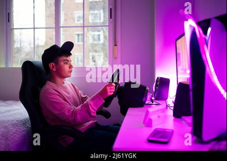 Boy playing video game on computer in bedroom at home Stock Photo