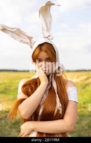 Sad woman in rabbit costume standing at farm Stock Photo
