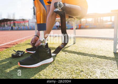 Hands of man tying shoelace on sunny day Stock Photo