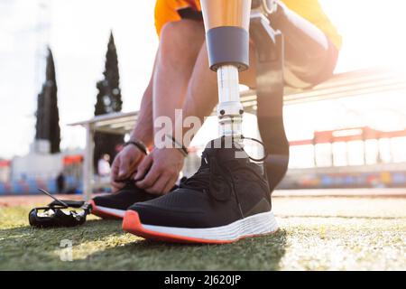 Hands of athlete tying shoelace on sunny day Stock Photo