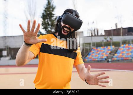 Bearded man wearing virtual reality simulator gesturing with mouth open Stock Photo