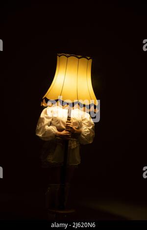 Young woman holding lamp in front of face Stock Photo