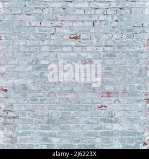 Gray-green brick wall weathered with age with remains of lime Stock Photo