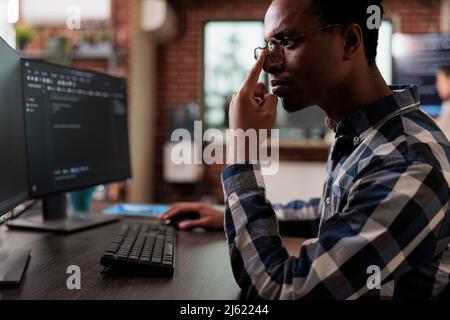 Thoughtful blockchain developer reflecting at low levels of security and how to improve mainframe defence system. Pensive network engineer thinking of failed data processing operation. Stock Photo