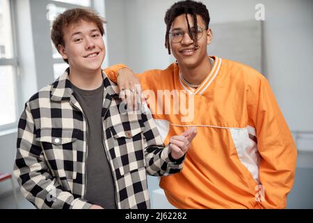 Smiling young man gesturing standing by friend Stock Photo