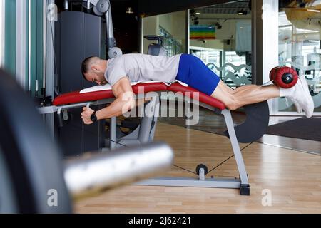 Man doing leg exercise in gym Stock Photo